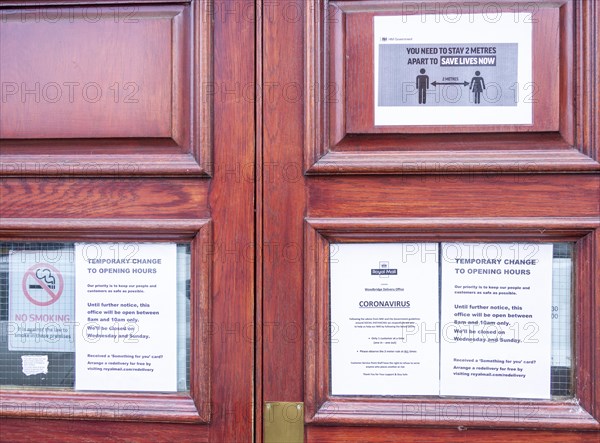 Coronavirus Covid-19 social distancing notices on door of Royal Mail delivery office, Woodbridge, Suffolk, England, UK