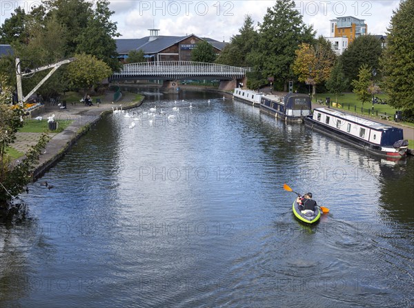 Narrow boats and kayak Kennet and Avon canal in the town centre of Newbury, Berkshire, England, UK