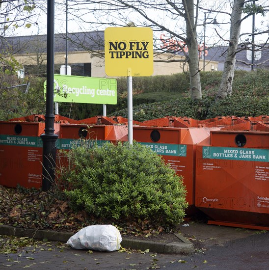 Rubbish bag dumped beneath No Fly Tipping sign, Sainsbury's recycling centre, Calne, England, United Kingdom, Europe