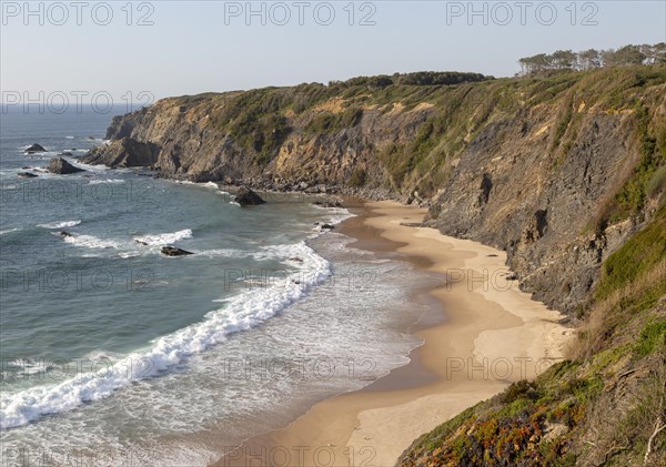 Secluded sandy beach in bay between rocky headlands at Parque Natural do Sudoeste Alentejano e Costa Vicentina, Natural Park, landscape view on the Ruta Vicentina long distance walking trail, at Praia dos Machados, Carvalhal, Alentejo Littoral, Portugal, southern Europe, Europe