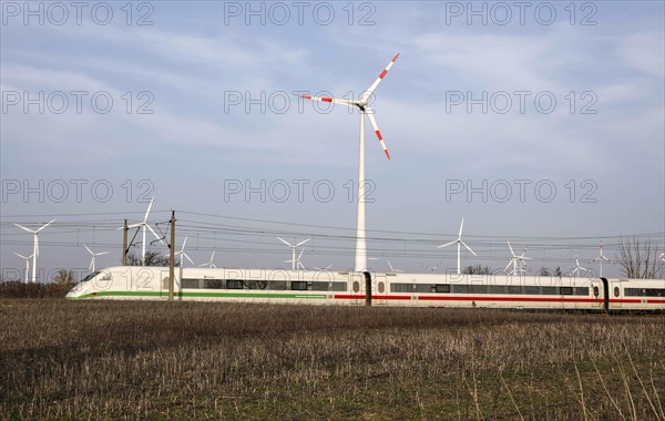 Deutsche Bahn ICE train passes a wind farm, Nauen, 03/03/2021
