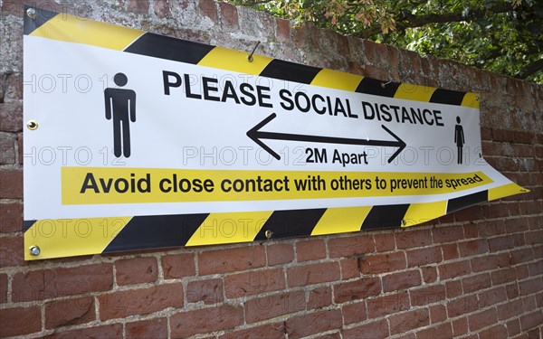 Please Social Distance 2 metres apart banner Avoid close contact with others to prevent the spread, UK