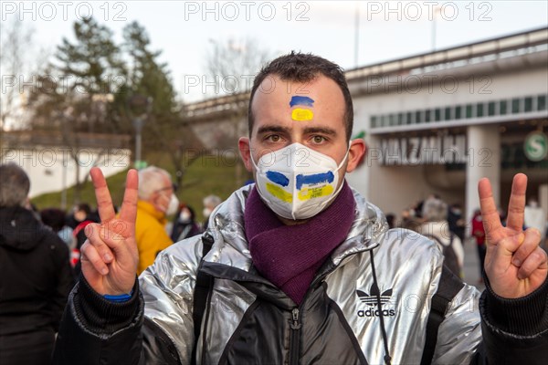 Peace demonstration against the war in Ukraine in the cities of Ludwigshafen and Mannheim with a joint closing rally in the cour d'honneur at Mannheim Palace. A young man of Ukrainian origin shows the peace sign. One of his friends is on a combat mission in Kharkiv