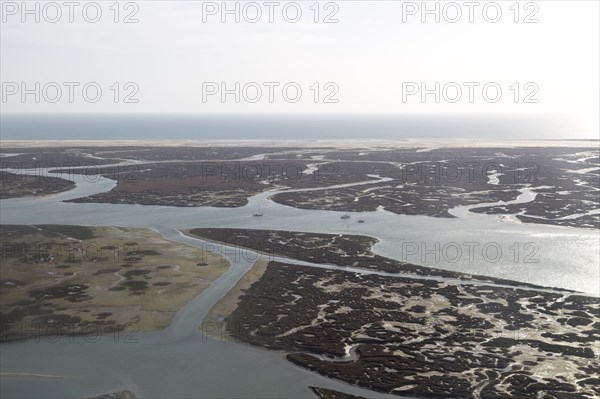 Coastal landscape of salt marsh and drainage channels along the coastline off Faro, Algarve, Portugal, Europe