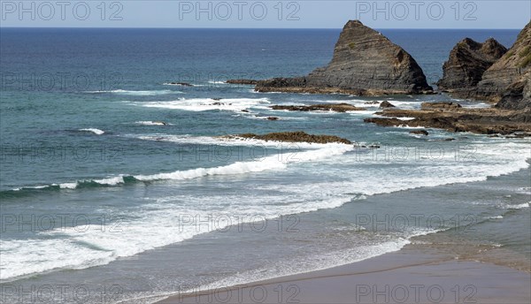 Atlantic Ocean waves breaking on rocky headland and bay with sandy beach, Praia de Odeceixe, Algarve, Portugal, Southern Europe, Europe