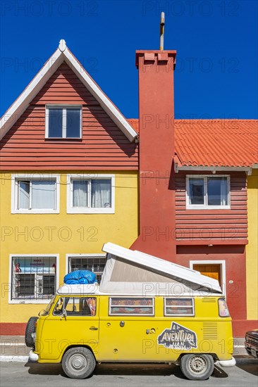 Yellow Volkswagen van in retro style in front of a yellow and red house, Ushuaia, Tierra del Fuego Island, Patagonia, Argentina, South America