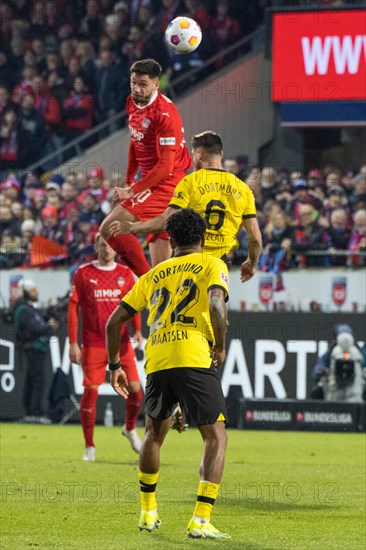 Football match, Tim KLEINDIENST 1.FC Heidenheim heads the ball to the side, Salih OeZCAN 6 Borussia Dortmund and Ian MAATSEN 22 Borussia Dortmund in front try to stop him, Voith-Arena football stadium, Heidenheim