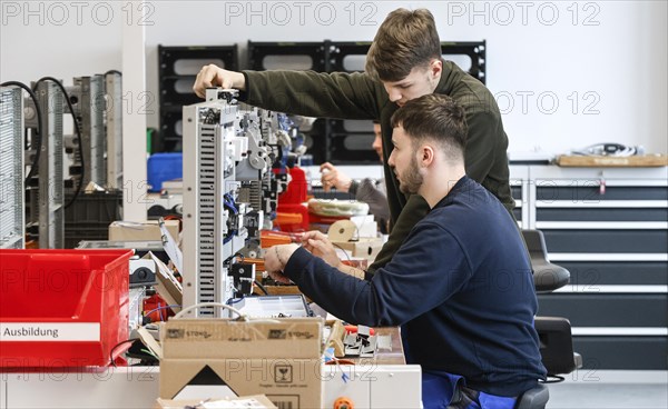 An electronics apprentice assembles a motor protection relay at a Deutsche Bahn training centre, Berlin, 07/02/2024