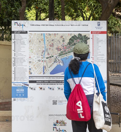 Person looking at plan map of city centre of Malaga, Andalusia, Spain showing locations of main tourist attractions