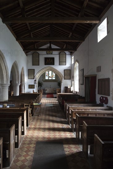 View past wooden pews to chancel arch and altar in sanctuary in the church at Milton Lilbourne, Wiltshire, England. The church was renovated in 1875, overseen by Reverend John Henry Gale vicar from 1846 until 1893