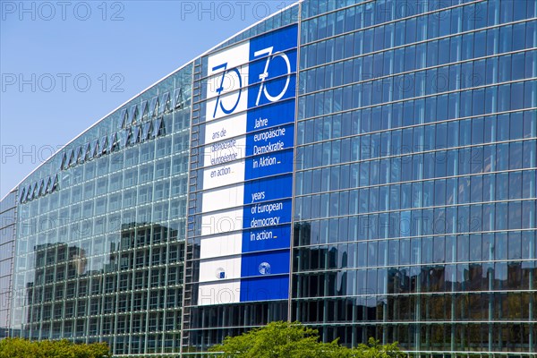 The back of the European Parliament in Strasbourg On the glass facade you can see a huge banner with the inscription 70 years of European democracy in action in French, German and English