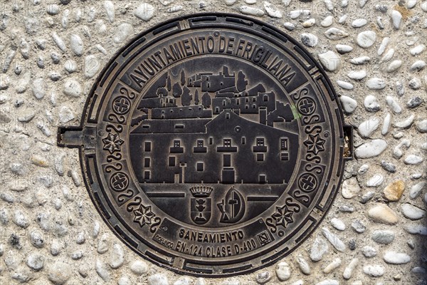 Looking down at metal manhole cover design image of village, Frigiliana, Axarquia, Andalusia, Spain, Europe