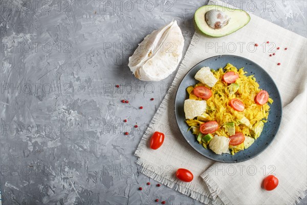 Fried pomelo with tomatoes and avocado on gray concrete background. Top view, copy space, myanmar food