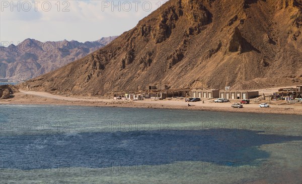 The coastline of the Red Sea with small resorts and the mountains in the background. Coral reef Blue Hole. Egypt, the Sinai Peninsula, Dahab