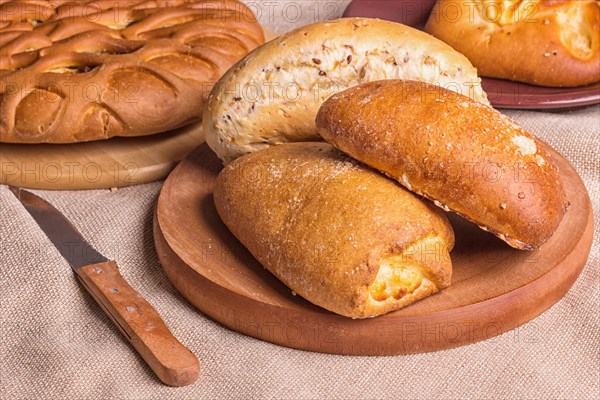 Sweet buns on a wooden board and linen tablecloth