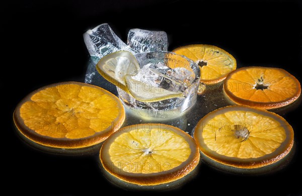 Transparent slices of fresh oranges and lemons on the glass with ice