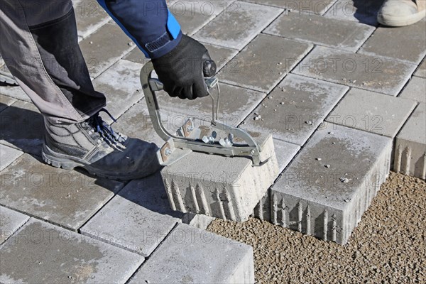 Workers lay paving stones