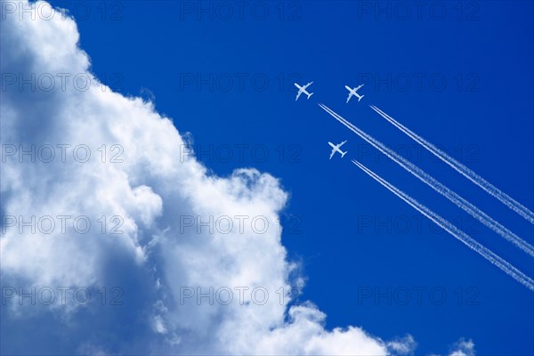 Three white passenger airplanes in blue sky