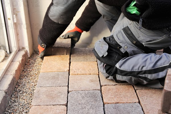 Worker lays paving stones