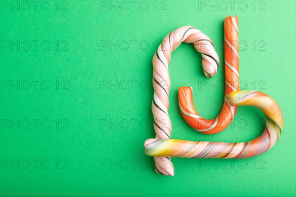 Single cane candy on green pastel background. copy space, top view, flat lay