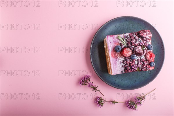 Berry cake with milk cream and blueberry jam on blue ceramic plate on a pink pastel background. top view, flat lay, copy space