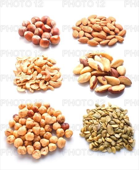 Piles of various nuts and seeds isolated on white background. hazelnut, brazil nut, almond, pumpkin seeds, cashew. top view