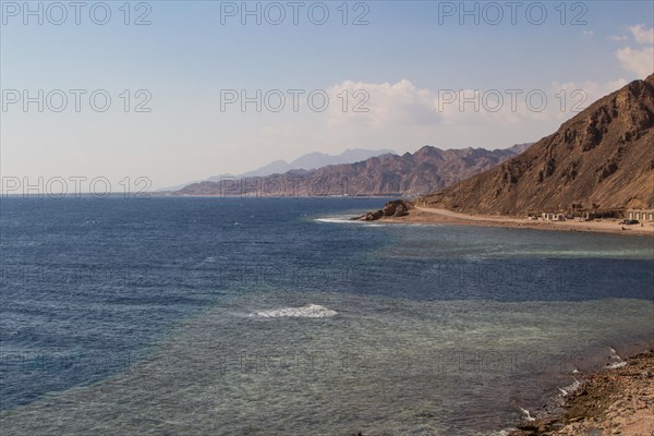 The coastline of the Red Sea with small resorts and the mountains in the background. Coral reef Blue Hole. Egypt, the Sinai Peninsula, Dahab