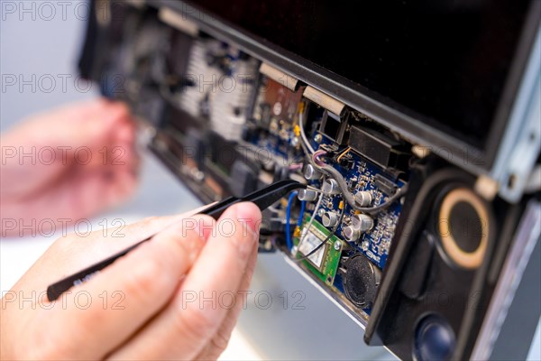 Close-up of the hands of a repairman fixing a computer in a workshop
