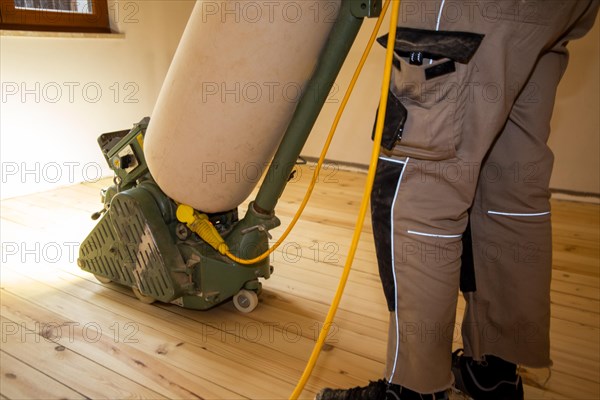 Craftsmen professionally sanding a plank floor