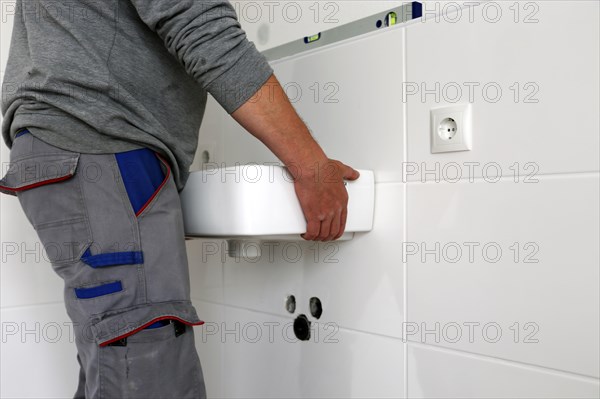 Plumber installs a new washbasin