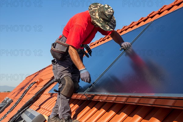 Installation of solar collectors for solar thermal energy. The company Hanschke Solarmontagen installs solar panels on a newly built apartment block in Mutterstadt (Palatinate)