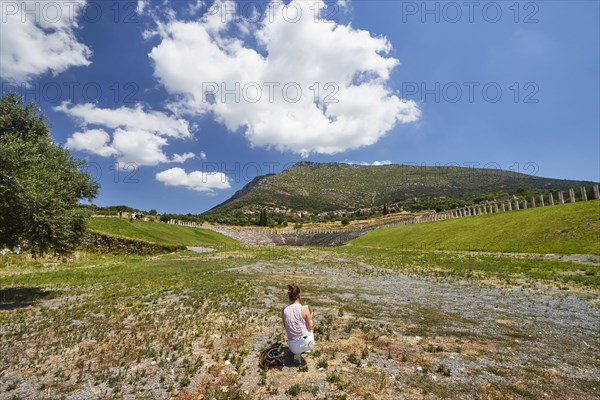 Person calmly contemplating the vast ancient stadium and the surrounding nature, Archaeological site, Ancient Messene, Capital of Messinia, Messini, Peloponnese, Greece, Europe