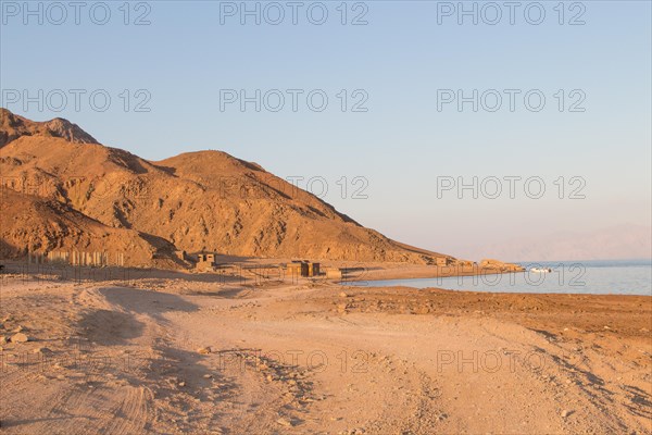 The coastline of the Red Sea and the mountains in the background, sunset. Egypt, the Sinai Peninsula, Dahab