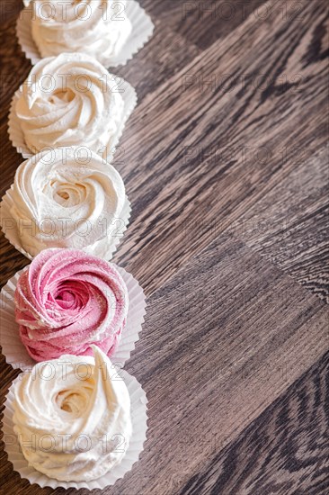 Pink and white homemade marshmallows on a gray wooden background. selective focus