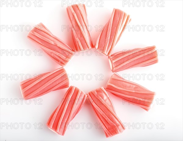 Heap of pink chewing caramel sugar candies isolated on white background. top view