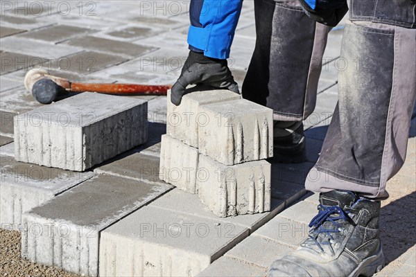 Workers lay paving stones