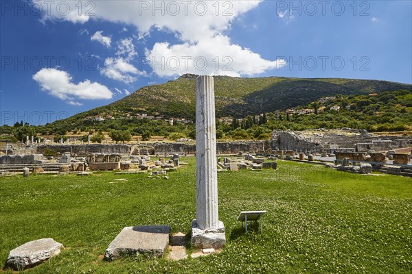 Ancient column stands in the foreground of a historical site with green meadow and mountains, Sanctuary of Asclepius, Archaeological Site, Ancient Messene, Capital of Messinia, Messini, Peloponnese, Greece, Europe