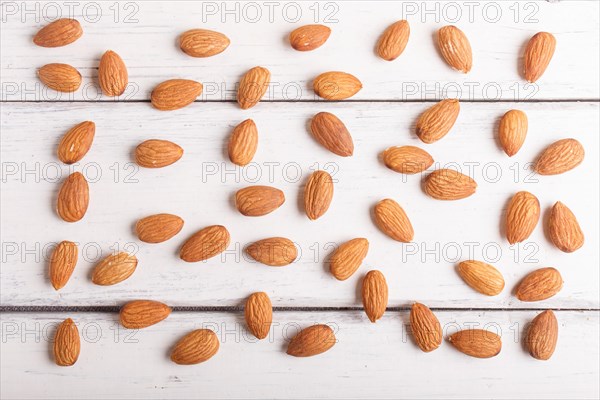 Pattern and texture made from almonds on white wooden background, flat lay. top view