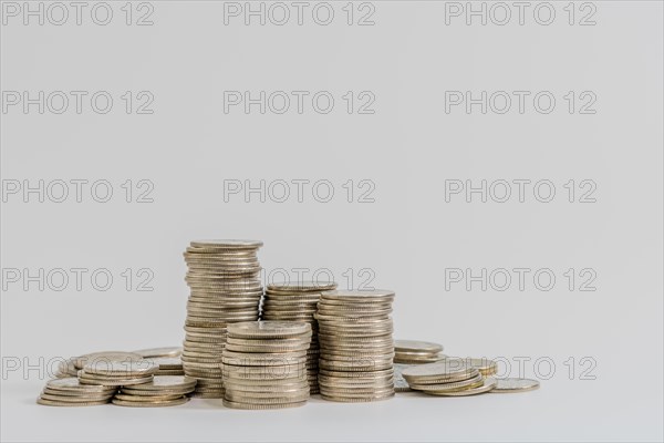 Stacks of coins in various sizes isolated on white background