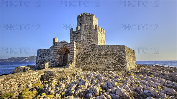 Ruins of a castle on a rocky coast with a clear sky, octagonal medieval tower. Islet of Bourtzi, sea fortress of Methoni, Peloponnese, Greece, Europe