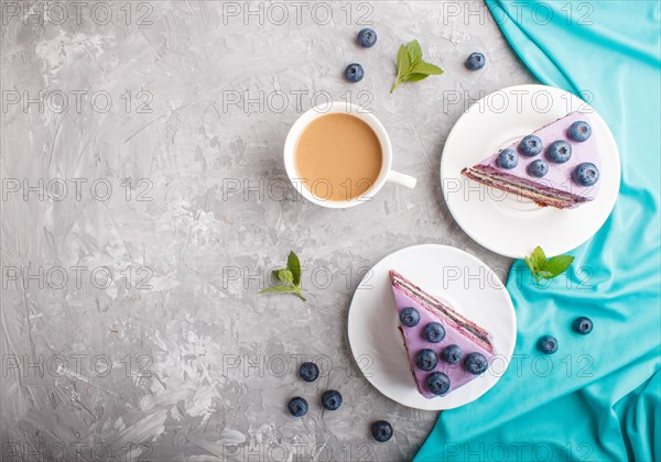 Homemade cake with souffle cream and blueberry jam with cup of coffee and fresh blueberries on a gray concrete background. top view, flat lay, copy space