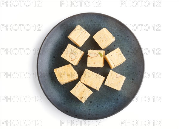 Traditional indian candy soan papdi in blue ceramic plate isolated on a white background. top view, close up, flat lay