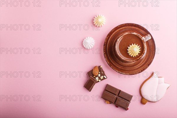 Cup of hot chocolate and pieces of milk chocolate with almonds on pink background. top view, flat lay, copy space