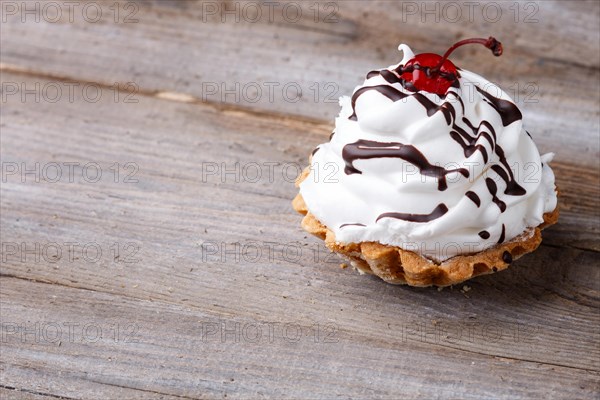 A cake with cream on a rustic wooden background with copy space