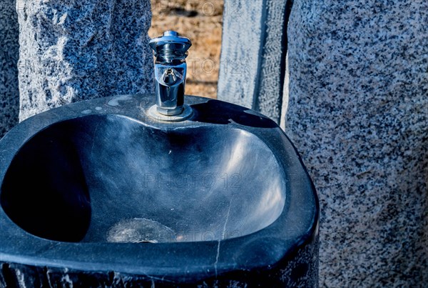 Closeup of drinking fountain in wilderness park on sunny winter day in South Korea