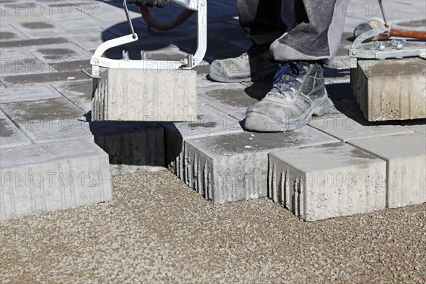 Workers lay paving stones