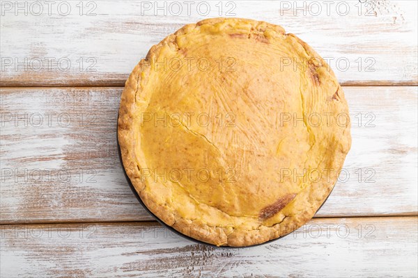 Autumn onion pie and cup of coffee on white wooden background. Top view, flat lay, close up