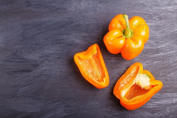 Sliced yellow sweet peppers isolated on black wooden background. closeup. top view. copyspace