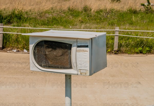 Small microwave oven on metal pole used as mailbox in South Korea