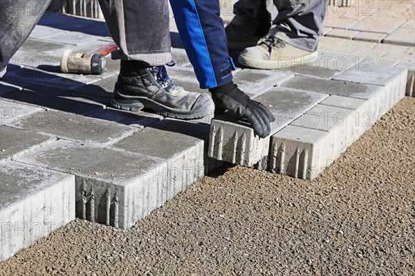 Workers lay paving stones